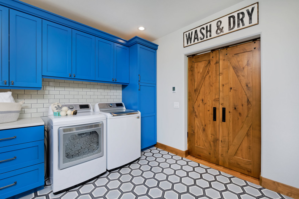 Foto di una lavanderia stile rurale di medie dimensioni con pareti blu e pavimento in legno massello medio