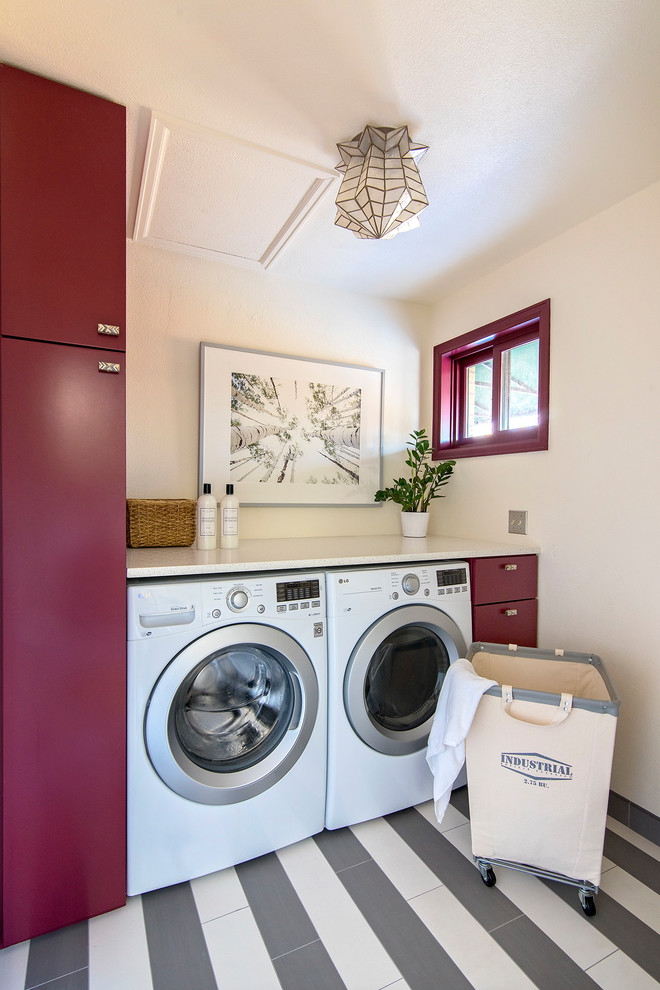 Inspiration för klassiska vitt tvättstugor enbart för tvätt, med släta luckor, vita väggar, en tvättmaskin och torktumlare bredvid varandra och flerfärgat golv