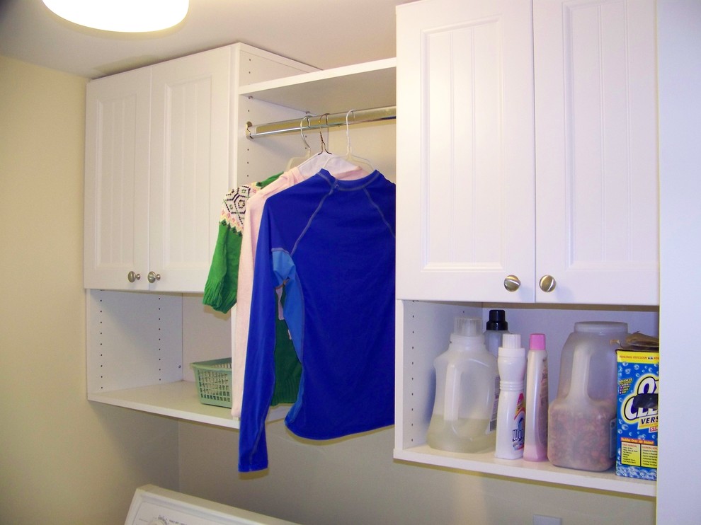 ボストンにある中くらいなトラディショナルスタイルのおしゃれな家事室 (白いキャビネット、黄色い壁、左右配置の洗濯機・乾燥機) の写真