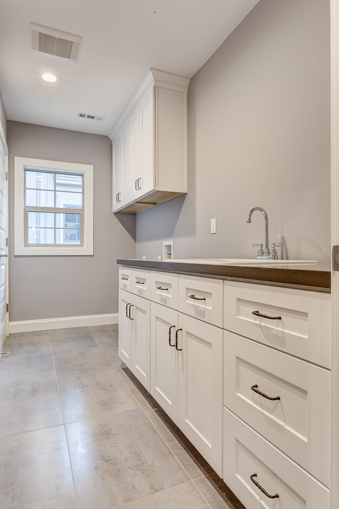 Mid-sized elegant galley ceramic tile dedicated laundry room photo in Sacramento with a drop-in sink, shaker cabinets, white cabinets, quartz countertops, gray walls and a side-by-side washer/dryer