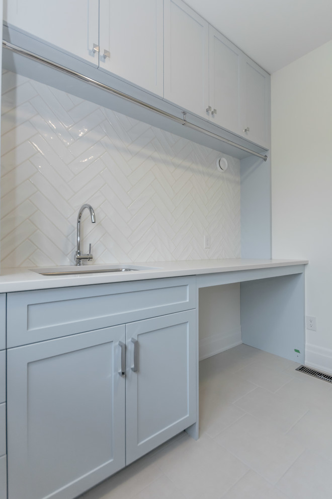 Exempel på en mellanstor klassisk vita linjär vitt tvättstuga enbart för tvätt, med en undermonterad diskho, skåp i shakerstil, blå skåp, bänkskiva i kvarts, grå väggar, klinkergolv i keramik och vitt golv