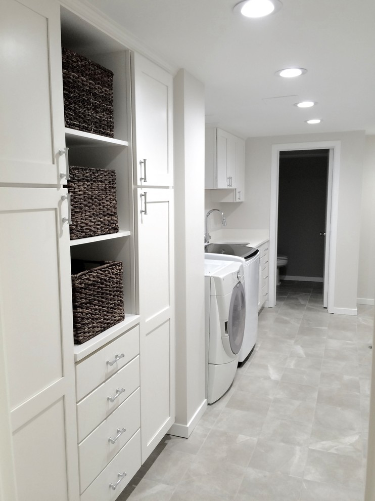 Idéer för mellanstora vintage linjära tvättstugor enbart för tvätt, med en undermonterad diskho, skåp i shakerstil, vita skåp, laminatbänkskiva, vita väggar, klinkergolv i keramik, en tvättmaskin och torktumlare bredvid varandra och grått golv
