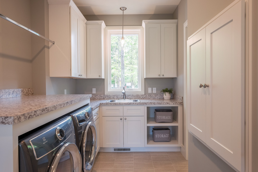 Large arts and crafts l-shaped light wood floor and beige floor dedicated laundry room photo in Grand Rapids with a drop-in sink, shaker cabinets, white cabinets, granite countertops, gray walls, a side-by-side washer/dryer and gray countertops