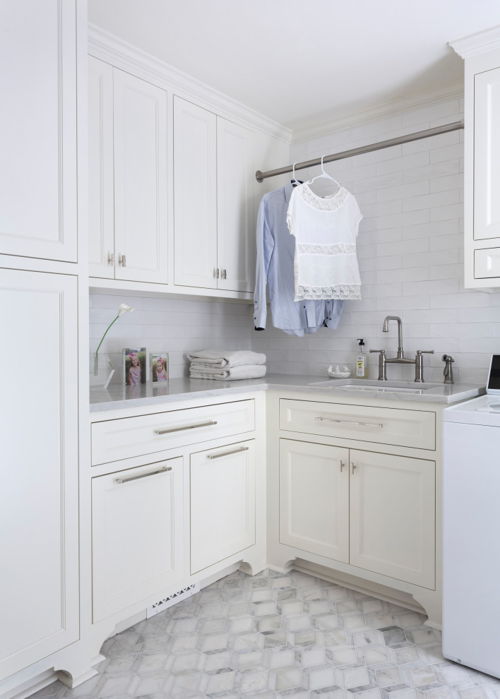 Idéer för att renovera en vintage grå l-formad grått tvättstuga enbart för tvätt, med en undermonterad diskho, luckor med infälld panel, vita skåp, en tvättmaskin och torktumlare bredvid varandra och grått golv