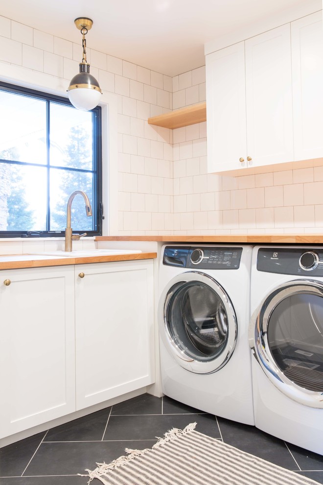 Esempio di una lavanderia moderna con lavello a vasca singola, ante in stile shaker, ante bianche, top in legno, pavimento in gres porcellanato, lavasciuga e pavimento grigio