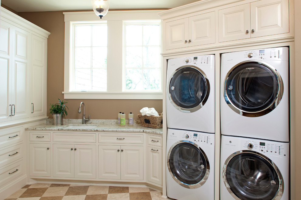 Immagine di una lavanderia tradizionale con ante beige, lavello sottopiano, pavimento beige e top beige