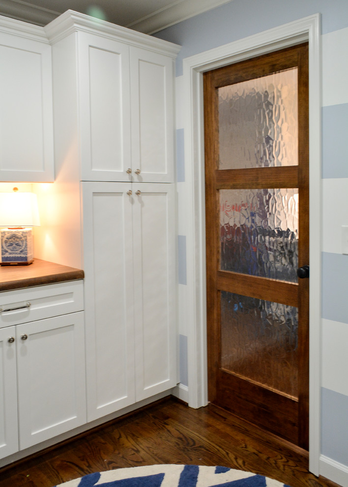 Example of a mid-sized cottage l-shaped dark wood floor laundry room design in Charlotte with a farmhouse sink, flat-panel cabinets, white cabinets and wood countertops