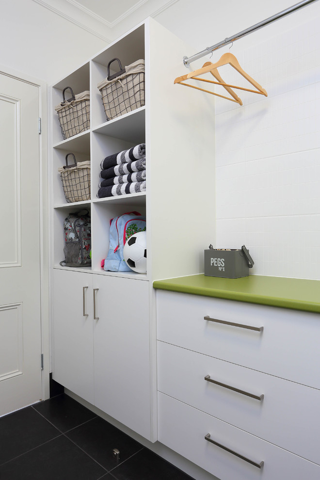 Idéer för en mellanstor modern l-formad tvättstuga enbart för tvätt, med släta luckor, vita skåp, laminatbänkskiva, vita väggar, klinkergolv i keramik och en tvättmaskin och torktumlare bredvid varandra