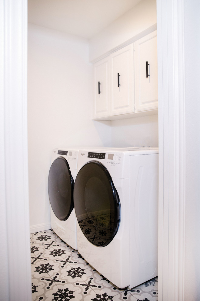 Dedicated laundry room - mid-sized transitional single-wall porcelain tile dedicated laundry room idea in Austin with raised-panel cabinets, white cabinets, white walls and a side-by-side washer/dryer
