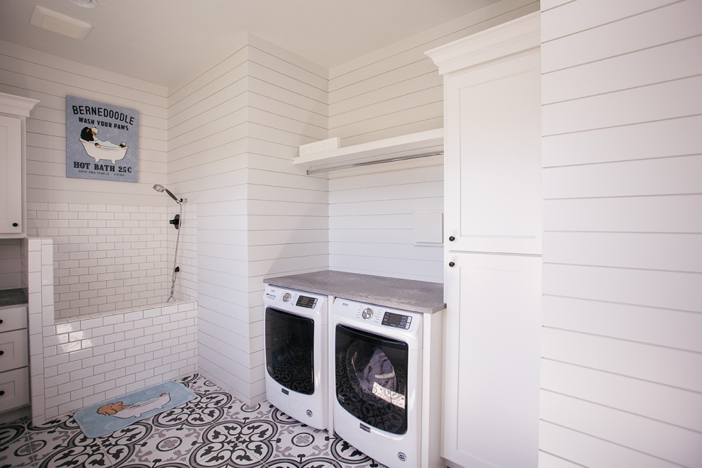 This is an example of a medium sized rural utility room in Portland with a built-in sink, white cabinets, window splashback, white walls, a side by side washer and dryer, multi-coloured floors and grey worktops.