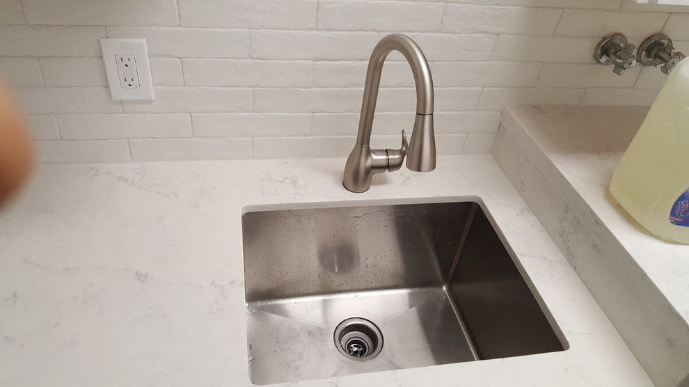 This is an example of a rural galley utility room in Miami with a belfast sink, white cabinets, wood worktops, ceramic flooring and white worktops.