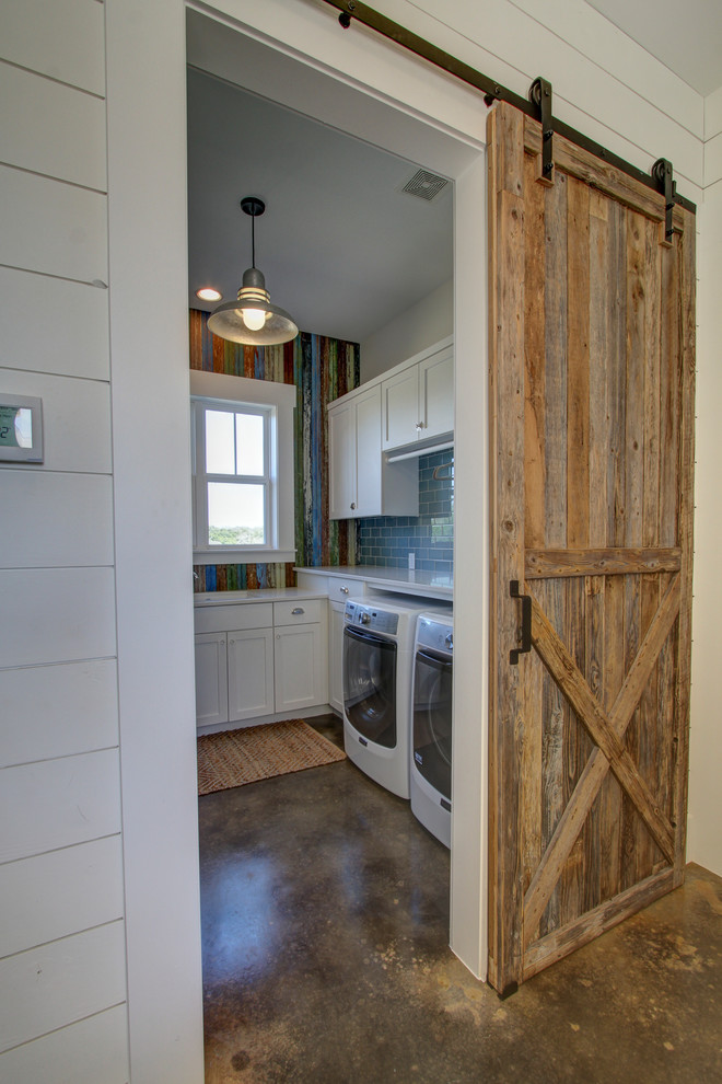 Photo of a medium sized country separated utility room in Austin with shaker cabinets, white cabinets, engineered stone countertops, concrete flooring, a side by side washer and dryer, brown floors, a submerged sink and multi-coloured walls.