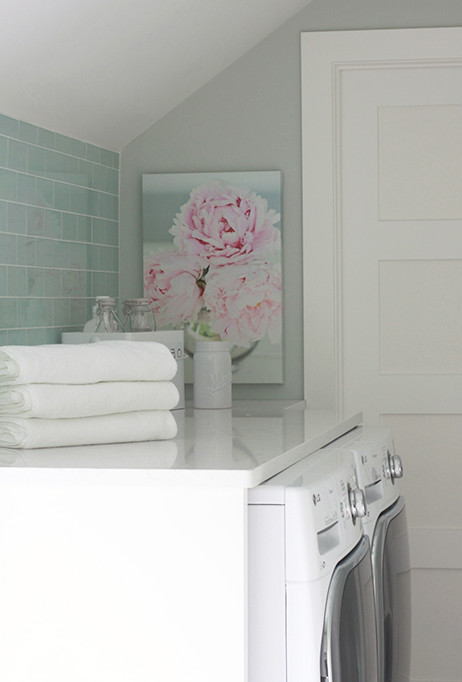 Bild på en liten lantlig linjär tvättstuga enbart för tvätt, med luckor med upphöjd panel, vita skåp, marmorbänkskiva, gröna väggar, klinkergolv i porslin och en tvättmaskin och torktumlare bredvid varandra