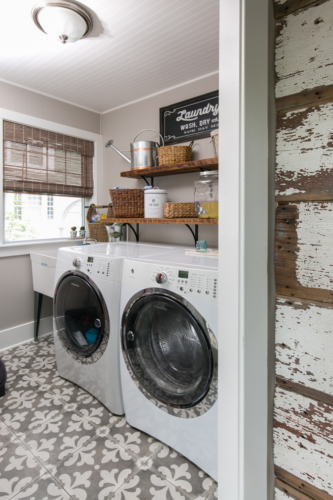 Foto di una lavanderia country con lavatoio, pareti grigie, lavatrice e asciugatrice affiancate e pavimento grigio