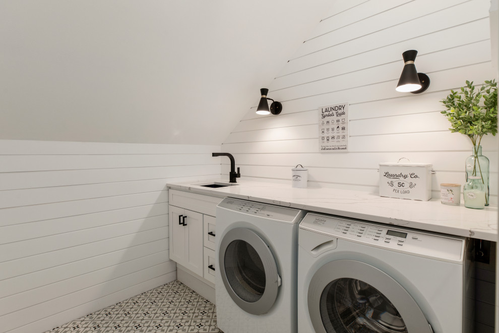Example of a farmhouse single-wall multicolored floor dedicated laundry room design in Seattle with an undermount sink, shaker cabinets, white cabinets, white walls, a side-by-side washer/dryer and multicolored countertops