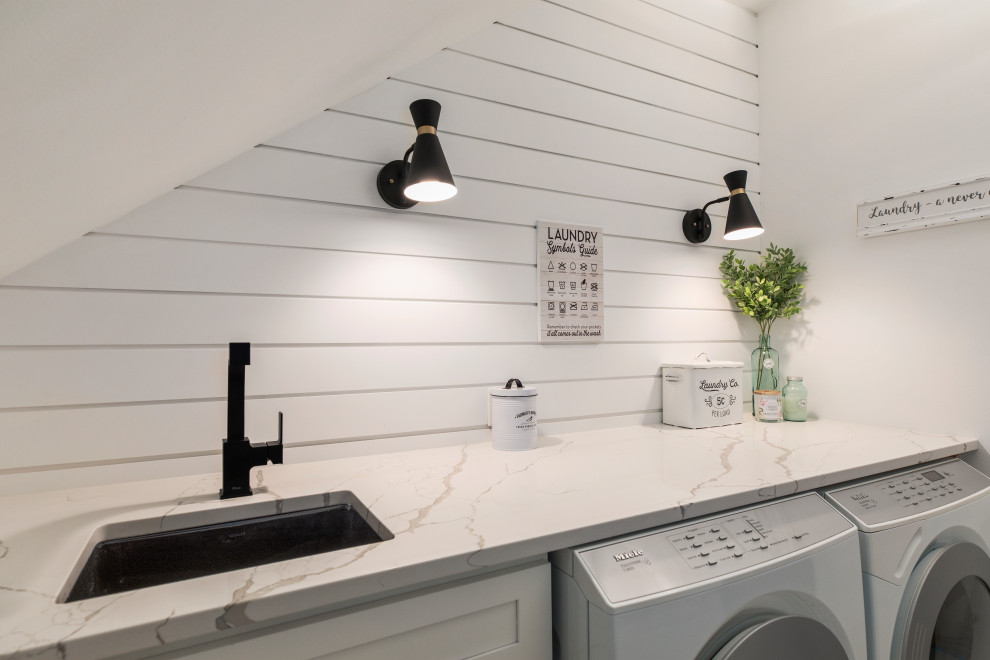 Mid-sized country single-wall porcelain tile and white floor dedicated laundry room photo in Seattle with an undermount sink, shaker cabinets, white cabinets, quartz countertops, white walls, a side-by-side washer/dryer and white countertops