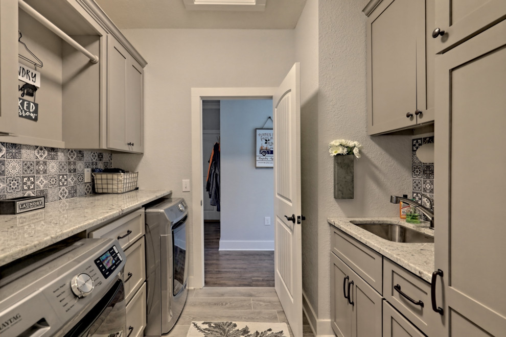Example of a mid-sized arts and crafts galley porcelain tile and gray floor dedicated laundry room design in Atlanta with an undermount sink, shaker cabinets, gray cabinets, granite countertops, multicolored backsplash, porcelain backsplash, gray walls, a side-by-side washer/dryer and multicolored countertops
