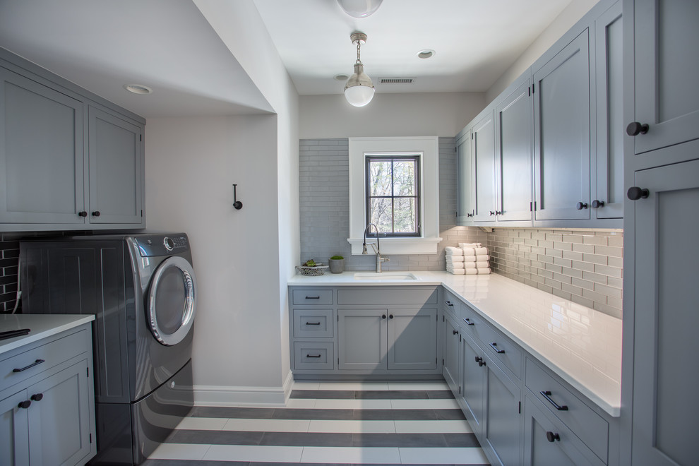 Große Landhausstil Waschküche in U-Form mit Unterbauwaschbecken, Schrankfronten im Shaker-Stil, grauen Schränken, grauer Wandfarbe, Porzellan-Bodenfliesen und Waschmaschine und Trockner nebeneinander in New York