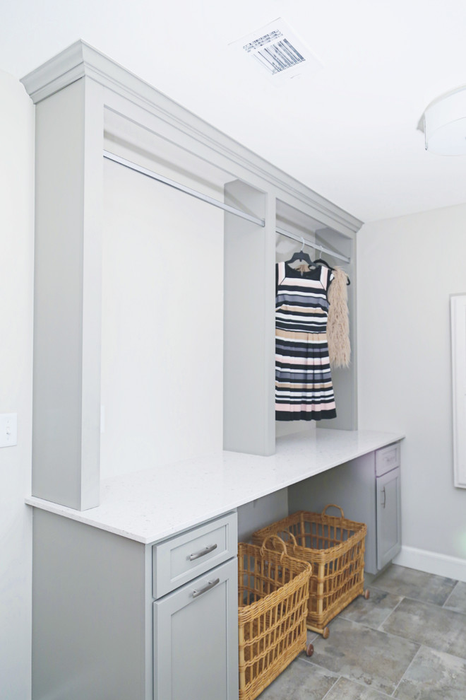 Klassisk inredning av en mellanstor tvättstuga enbart för tvätt, med en undermonterad diskho, grå väggar, klinkergolv i porslin och grått golv