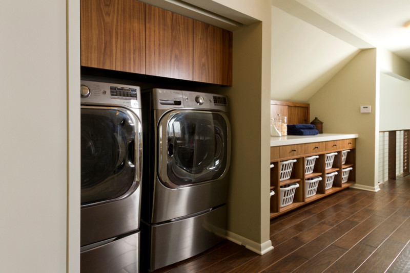 ミネアポリスにある高級な中くらいなコンテンポラリースタイルのおしゃれな洗濯室 (I型、フラットパネル扉のキャビネット、中間色木目調キャビネット、クオーツストーンカウンター、グレーの壁、濃色無垢フローリング、目隠し付き洗濯機・乾燥機) の写真