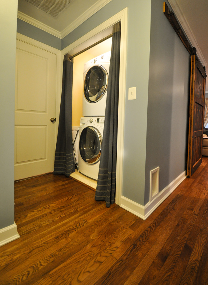 Klassischer Hauswirtschaftsraum mit Waschmaschinenschrank, blauer Wandfarbe und braunem Holzboden in Washington, D.C.