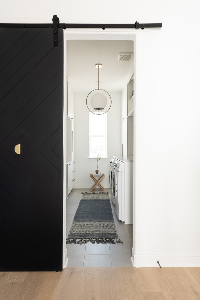 Imagen de cuarto de lavado de galera minimalista grande con fregadero sobremueble, puertas de armario blancas, paredes blancas, suelo de madera clara y encimeras beige