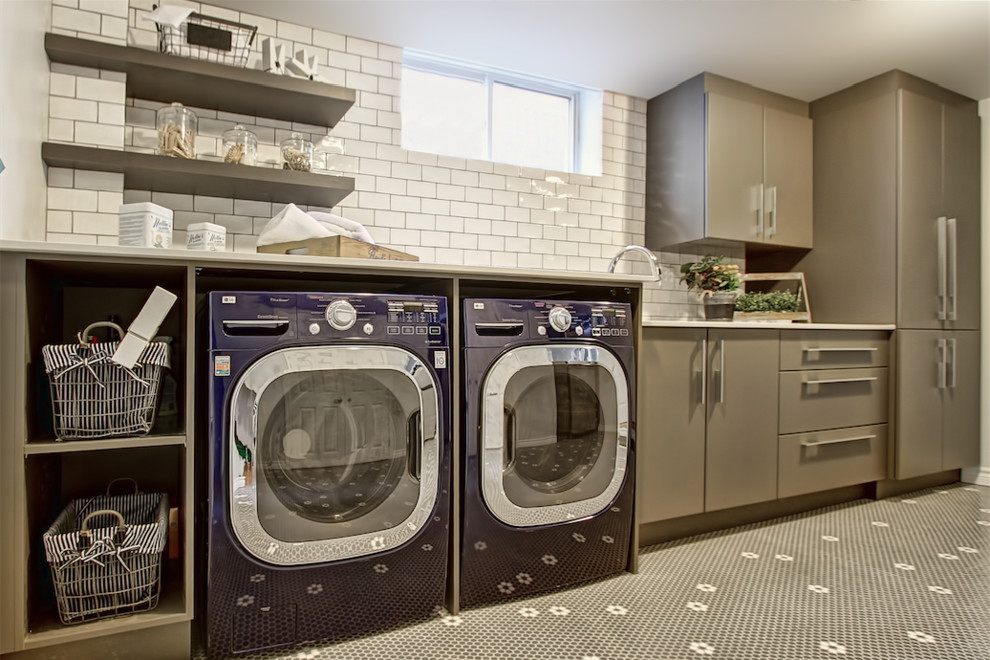 Contemporary utility room in Toronto with a submerged sink, flat-panel cabinets, grey cabinets, engineered stone countertops, ceramic flooring and a side by side washer and dryer.