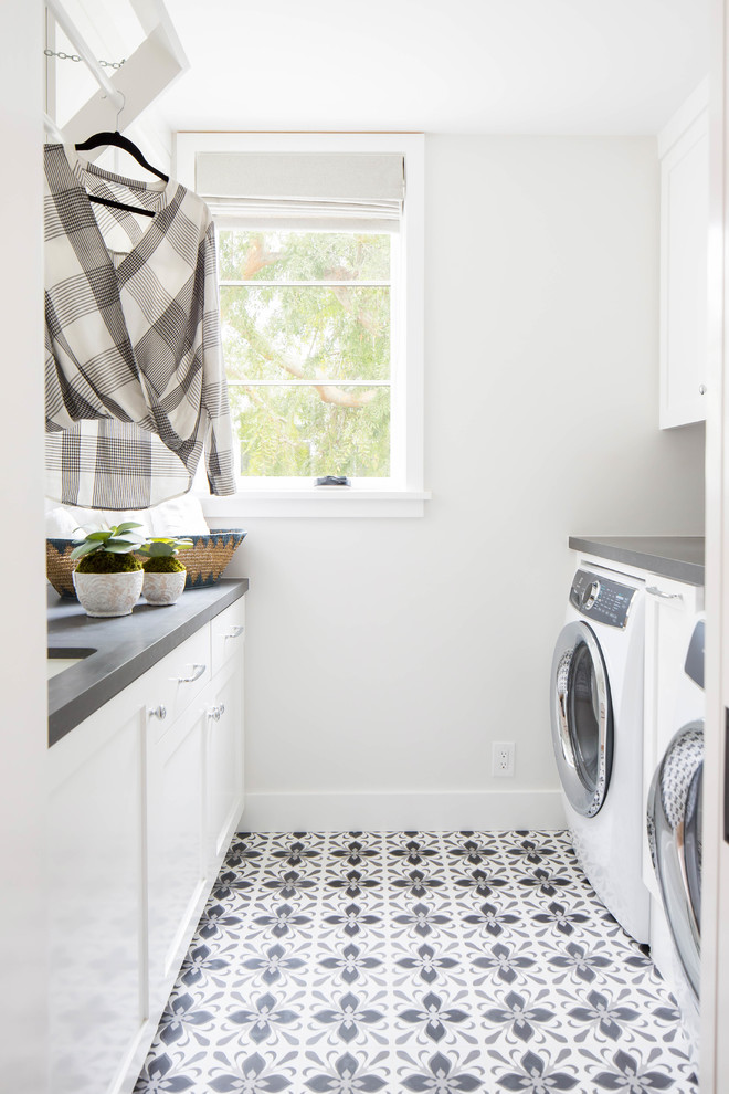Mid-sized beach style galley gray floor dedicated laundry room photo in Orange County with an undermount sink, shaker cabinets, white cabinets, white walls, a side-by-side washer/dryer and gray countertops