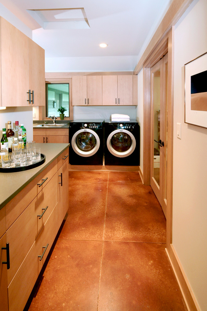 Ispirazione per una lavanderia contemporanea con pavimento in cemento e pavimento arancione