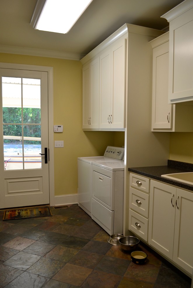 Mid-sized eclectic single-wall slate floor utility room photo in Atlanta with an utility sink, flat-panel cabinets, white cabinets, laminate countertops, yellow walls and a side-by-side washer/dryer