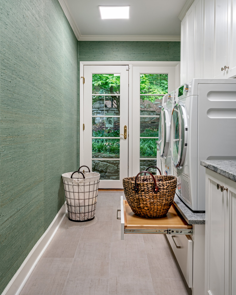Immagine di una sala lavanderia chic con ante in stile shaker, ante bianche, pareti verdi, lavatrice e asciugatrice affiancate, pavimento beige e carta da parati