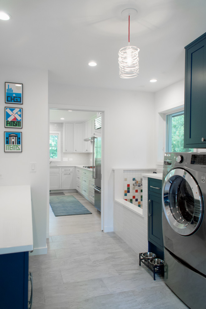 Esempio di una lavanderia multiuso moderna di medie dimensioni con ante con riquadro incassato, ante blu, top in quarzo composito, pareti bianche, pavimento in gres porcellanato, lavatrice e asciugatrice affiancate, pavimento grigio e top bianco
