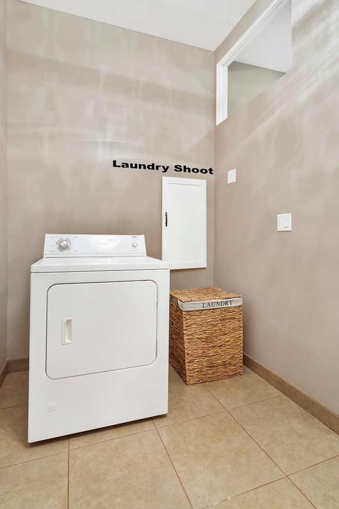 Bild på en stor retro vita l-formad vitt tvättstuga enbart för tvätt, med en nedsänkt diskho, skåp i shakerstil, vita skåp, bänkskiva i kvartsit, orange väggar, klinkergolv i keramik, en tvättmaskin och torktumlare bredvid varandra och beiget golv