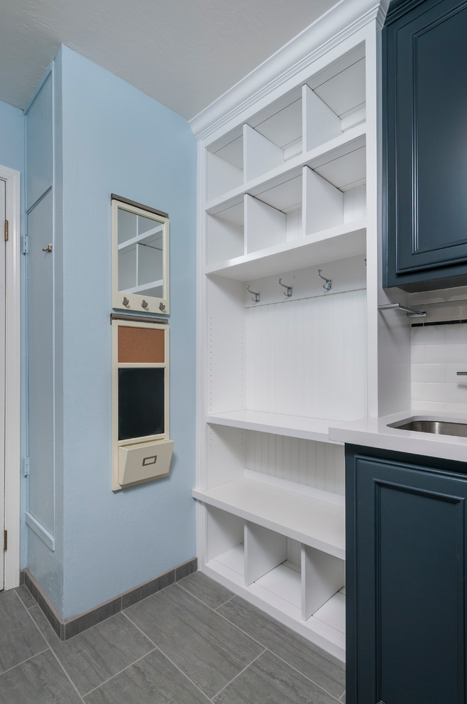 Example of a mid-sized transitional single-wall porcelain tile utility room design in San Francisco with an undermount sink, recessed-panel cabinets, quartz countertops, blue walls, a side-by-side washer/dryer and blue cabinets