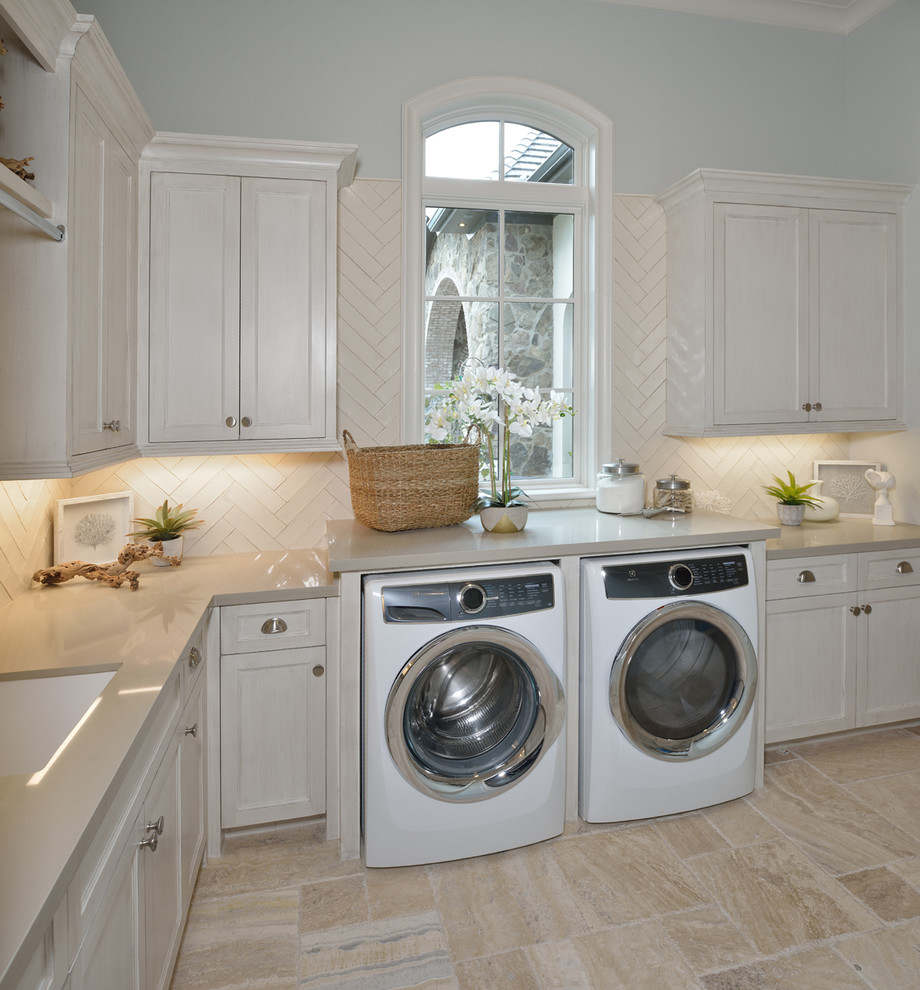 Geräumige Klassische Waschküche in L-Form mit Unterbauwaschbecken, Schrankfronten mit vertiefter Füllung, beigen Schränken, Travertin, Waschmaschine und Trockner nebeneinander, beigem Boden, Quarzwerkstein-Arbeitsplatte und grauer Wandfarbe in Houston