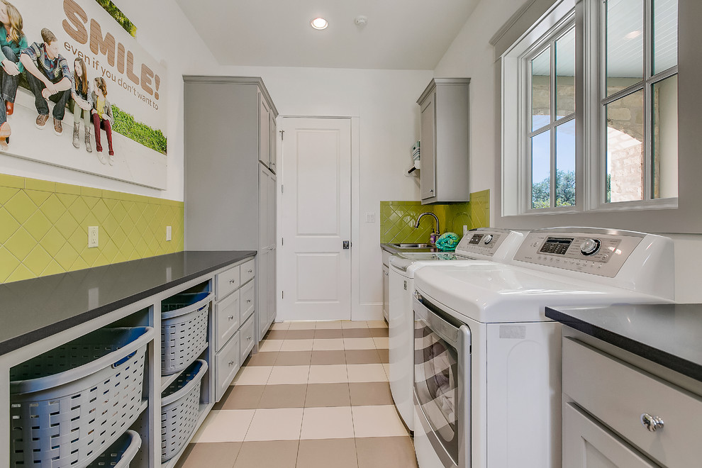 Inspiration for a large traditional galley separated utility room in Austin with a built-in sink, shaker cabinets, grey cabinets, white walls, ceramic flooring, a side by side washer and dryer, beige floors, black worktops and engineered stone countertops.