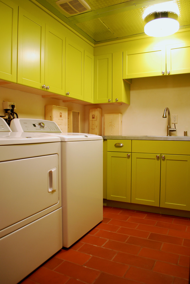 Bild på en mellanstor eklektisk u-formad tvättstuga enbart för tvätt, med en undermonterad diskho, luckor med upphöjd panel, gröna skåp, bänkskiva i rostfritt stål, vita väggar, klinkergolv i terrakotta och en tvättmaskin och torktumlare bredvid varandra