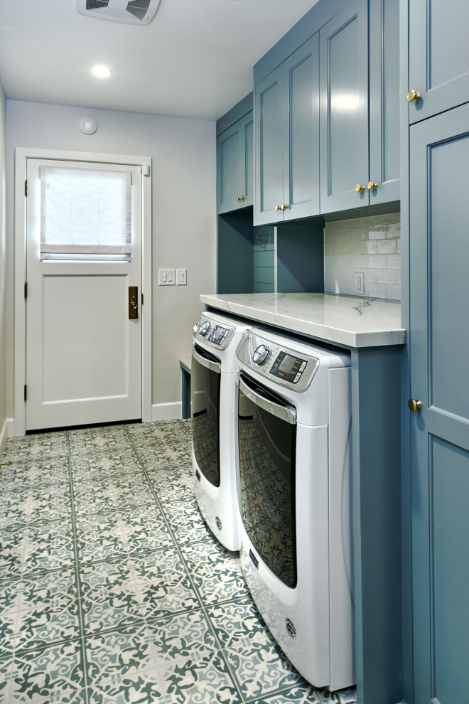 Example of a mid-sized transitional single-wall porcelain tile, blue floor and shiplap wall utility room design in San Francisco with recessed-panel cabinets, blue cabinets, quartzite countertops, white backsplash, ceramic backsplash, gray walls, a side-by-side washer/dryer and white countertops