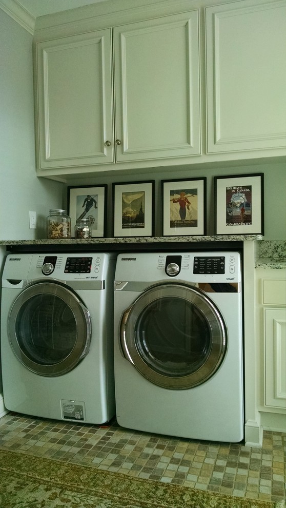 Exempel på en liten modern parallell tvättstuga enbart för tvätt, med en undermonterad diskho, luckor med upphöjd panel, vita skåp, granitbänkskiva, grå väggar, klinkergolv i keramik och en tvättmaskin och torktumlare bredvid varandra