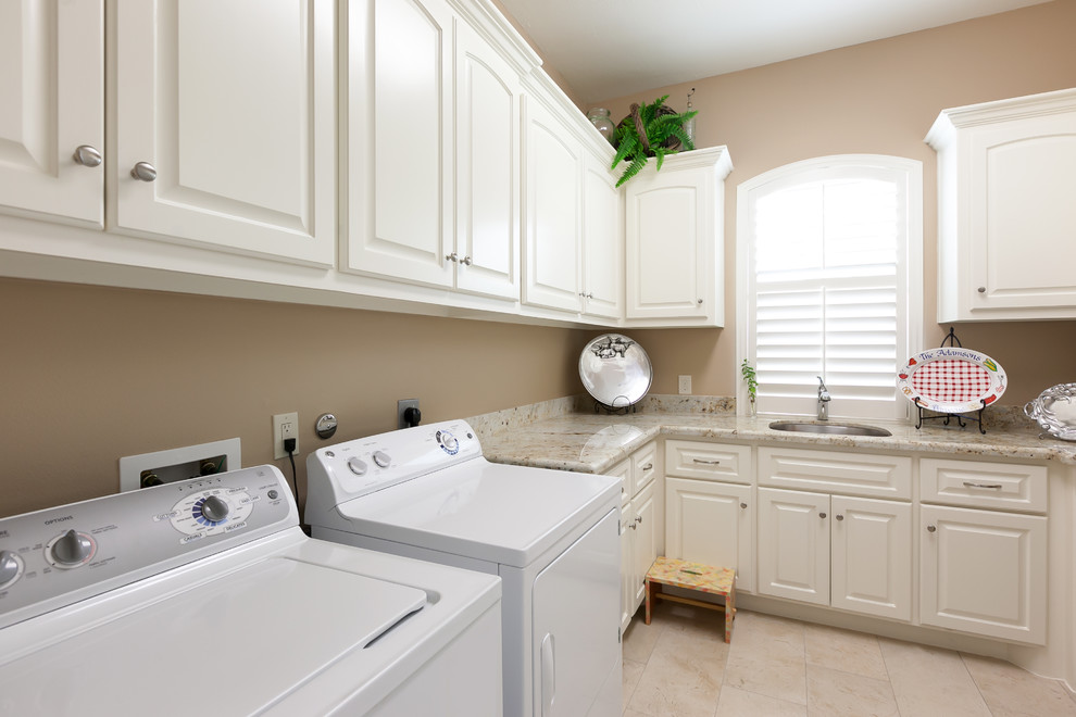 Idee per una sala lavanderia chic con lavello sottopiano, ante con bugna sagomata, ante bianche, pareti marroni e lavatrice e asciugatrice affiancate