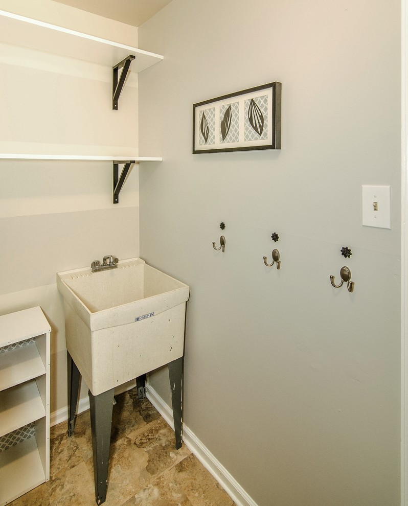 Ejemplo de cuarto de lavado clásico renovado pequeño con pila para lavar, paredes grises, suelo vinílico y lavadora y secadora juntas