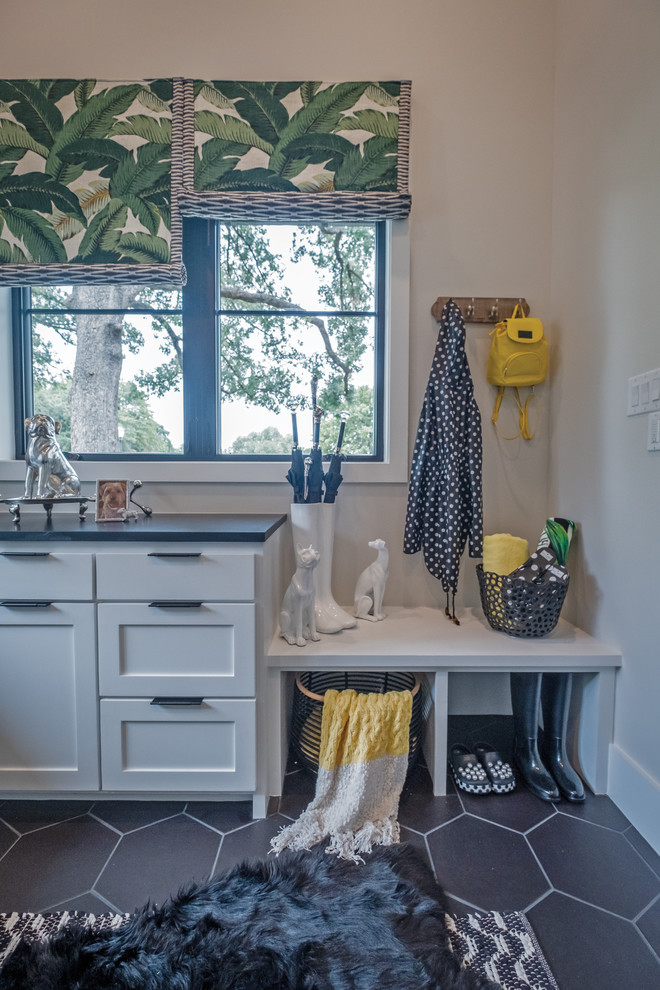 Dedicated laundry room - mid-sized eclectic u-shaped porcelain tile and gray floor dedicated laundry room idea in Dallas with a farmhouse sink, shaker cabinets, white cabinets, soapstone countertops, multicolored walls, a side-by-side washer/dryer and gray countertops