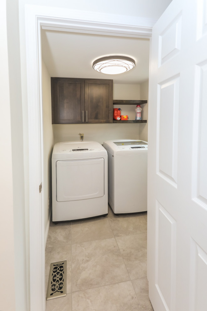 Inspiration for a small transitional single-wall porcelain tile and gray floor dedicated laundry room remodel in Atlanta with shaker cabinets, dark wood cabinets, white walls and a side-by-side washer/dryer