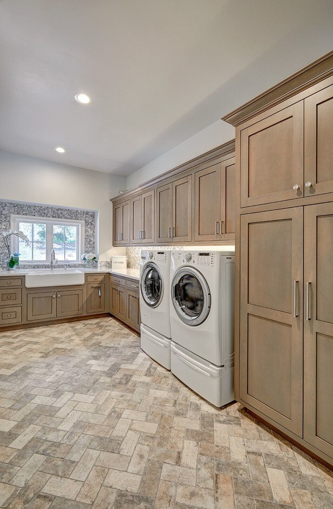 Large elegant l-shaped travertine floor and multicolored floor dedicated laundry room photo in Sacramento with a farmhouse sink, shaker cabinets, dark wood cabinets, gray walls and a side-by-side washer/dryer