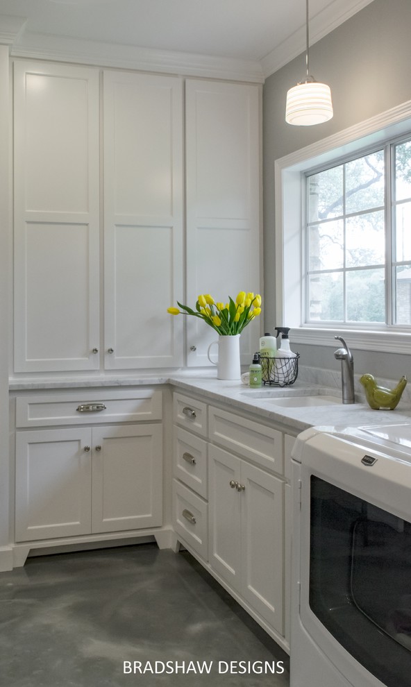 Utility room - large traditional l-shaped utility room idea in Austin with an undermount sink, recessed-panel cabinets, white cabinets, marble countertops, gray walls and a side-by-side washer/dryer