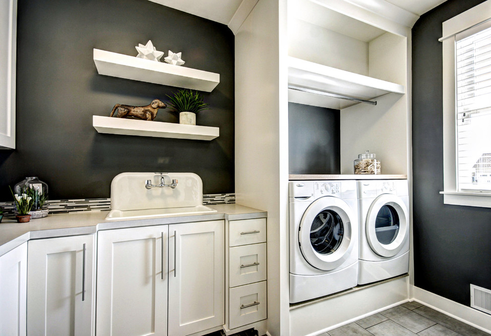 Foto på en vintage tvättstuga, med en nedsänkt diskho, skåp i shakerstil, vita skåp, svarta väggar och en tvättmaskin och torktumlare bredvid varandra