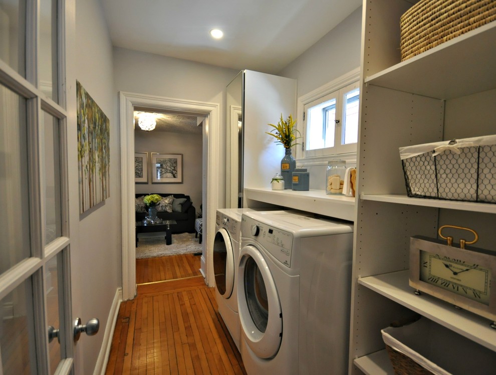 Multifunktionaler, Zweizeiliger, Kleiner Moderner Hauswirtschaftsraum mit grauer Wandfarbe, braunem Holzboden und Waschmaschine und Trockner nebeneinander in Ottawa