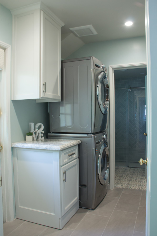 Example of a small transitional single-wall porcelain tile and gray floor dedicated laundry room design in Los Angeles with shaker cabinets, white cabinets, quartz countertops, green walls, a stacked washer/dryer and green countertops