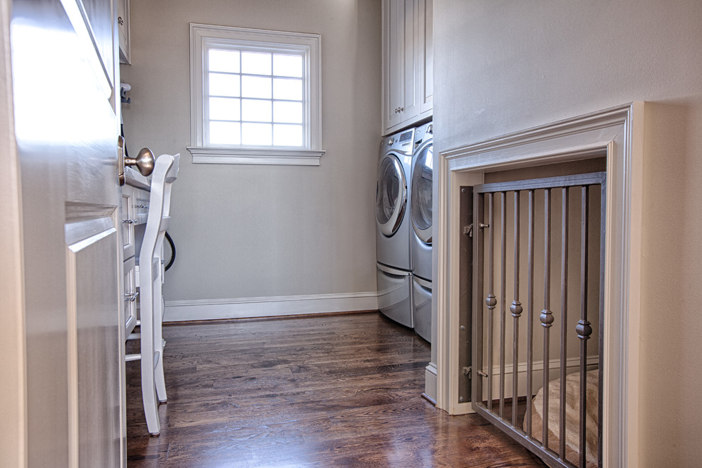 Imagen de cuarto de lavado de galera minimalista de tamaño medio con puertas de armario blancas, encimera de mármol, suelo de madera en tonos medios y lavadora y secadora juntas
