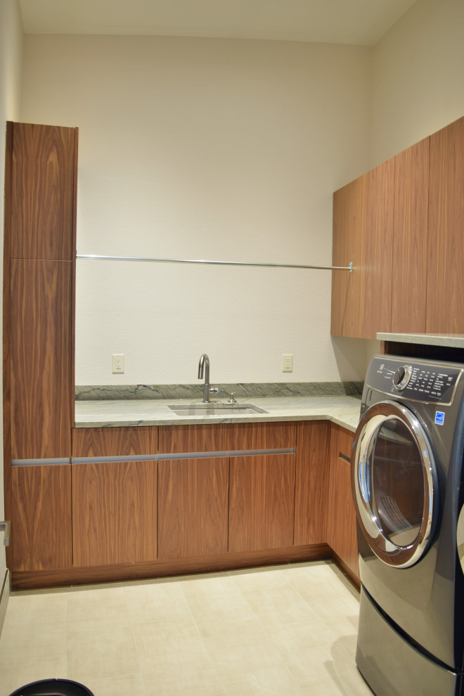 Ispirazione per una sala lavanderia minimal di medie dimensioni con lavello sottopiano, ante lisce, ante in legno scuro e lavasciuga
